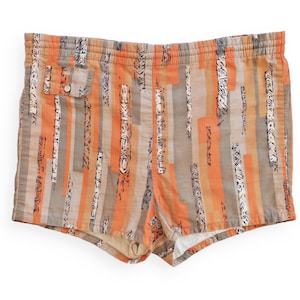 May include: Orange and gray striped swim trunks with a black and white abstract pattern.