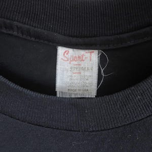 May include: A black t-shirt with a white tag that reads "Sport-T" and has sizing information.