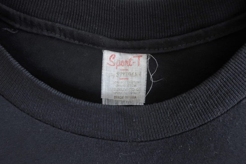 May include: A black t-shirt with a white tag that reads "Sport-T" and has sizing information.