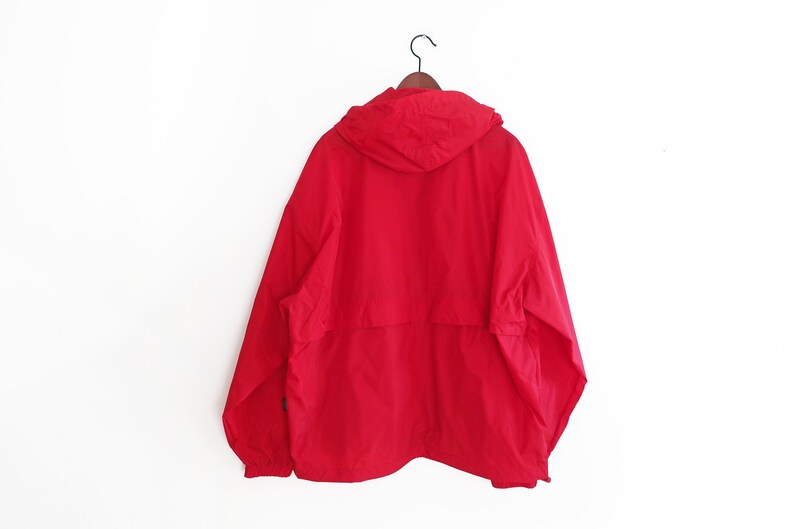 May include: A red hooded jacket with a zip fastening and a drawstring hood.