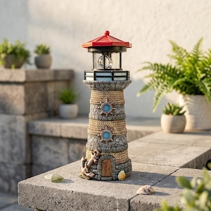 Pode incluir: Um farol decorativo com telhado vermelho, acabamento preto e design de pedra e corda. O farol apresenta uma luz e detalhes náuticos, incluindo um leme e uma âncora. É projetado para uso ao ar livre.
