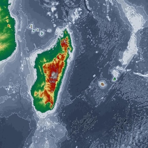 May include: An aerial view of a topographic map of the ocean floor and landmasses. The map uses a color gradient, with green and yellow representing higher elevations and red indicating the highest points. The ocean is depicted in shades of blue.