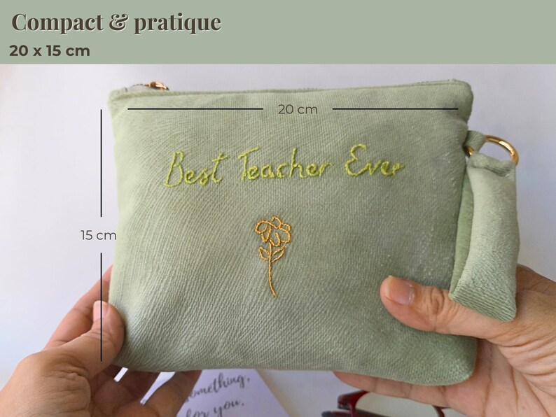 Op de afbeelding: Een saliegroene etui met de geborduurde tekst "Best Teacher Ever" en een gouden bloemdesign. De etui meet 20 cm x 15 cm en heeft een gouden rits en een klein handvat.