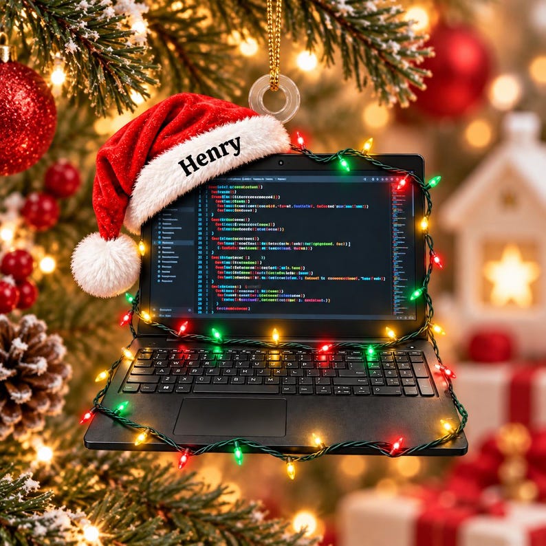 May include: A black laptop ornament featuring a red and white Santa hat with the name Henry printed on the brim. The screen displays lines of computer code, and the device is wrapped in a string of small, glowing multicoloured Christmas lights.