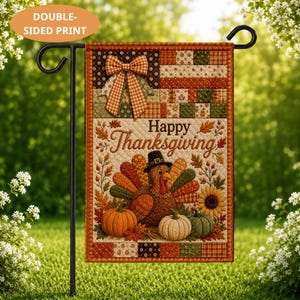 May include: A rectangular garden flag featuring a quilted pattern with a brown turkey wearing a black hat, orange and white pumpkins, and a sunflower. The text Happy Thanksgiving is centered. The flag has a double-sided print and hangs on a black metal stand.
