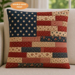 May include: Square throw pillow with a quilted design resembling the American flag. The pillow features a blue field with white stars and red and white stripes. The pillow is double-sided.