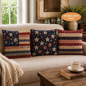 May include: Three square throw pillows featuring a quilted texture and a patriotic theme. One pillow displays a flag pattern, another has a star-filled design, and the third shows horizontal stripes. All pillows feature red, white, and blue colors.