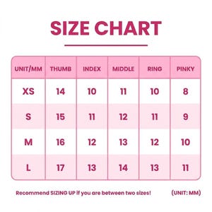 以下が含まれることがあります： ピンクと白のサイズチャートで、上部に「SIZE CHART」という文字があります。チャートには、XSからLまでのサイズがリストされており、親指、人差し指、中指、薬指、小指の対応する測定値がミリメートルで表示されています。「Recommend SIZING UP if you are between two sizes!」というテキストが下にあります。