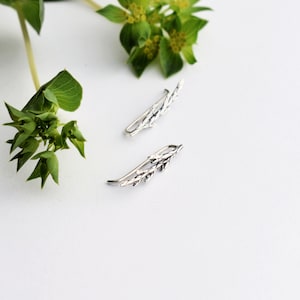 Puede incluir: Un par de pendientes de plata en forma de ramas delicadas con hojas. Los pendientes est&aacute;n dise&ntilde;ados para ser usados en la parte superior de la oreja.