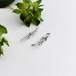 Puede incluir: Un par de pendientes de plata en forma de ramas delicadas con peque&ntilde;as hojas. Los pendientes est&aacute;n dise&ntilde;ados para ser usados en la parte superior de la oreja.