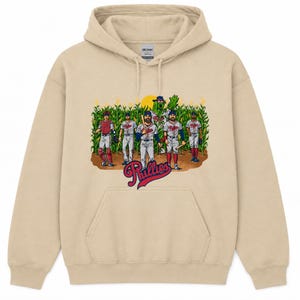 Può includere: Una felpa con cappuccio color sabbia con una stampa grafica di cinque giocatori di baseball e una mascotte verde in un campo di mais. Sotto le figure, la parola Phillies è scritta in un carattere corsivo rosso e blu con un contorno bianco.