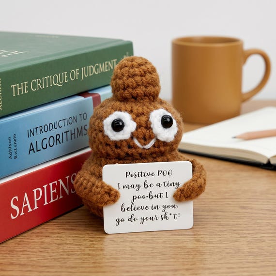 A hand-crocheted poop emoji plush paired with a heartfelt positive affirmation card — absurd emotional support, executed with real craft.