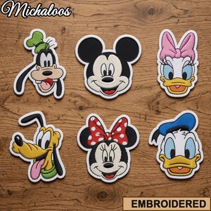 May include: Six embroidered patches featuring the faces of Goofy, Mickey Mouse, Daisy Duck, Pluto, Minnie Mouse, and Donald Duck. Each patch has a white border and detailed stitching. The text Michaloos appears in the top left corner.
