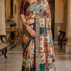 May include: A colorful patterned saree with a burgundy blouse. The saree features a patchwork design with various motifs in shades of blue, green, red, and yellow. The saree is draped over a person.