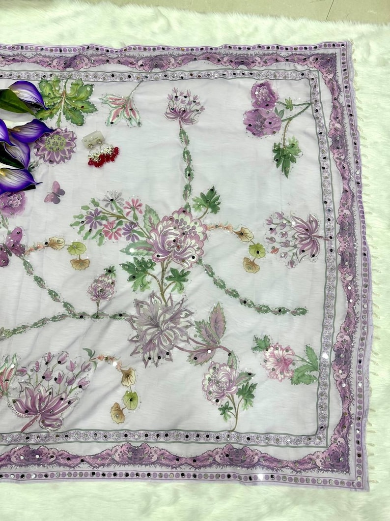 May include: A light purple scarf with intricate floral embroidery in shades of purple, pink, and green. The scarf features a delicate border with small mirrored accents. The design includes butterflies and other floral elements.