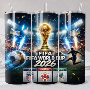 May include: A cylindrical tumbler featuring a FIFA World Cup 2026 graphic with a golden trophy, a soccer ball, a player in motion, and the flags of the USA, Canada, and Mexico. The design includes stadium lights, fireworks, and confetti.