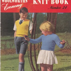 May include: A vintage knitting pattern book cover featuring two children, a boy wearing a yellow sweater vest and a girl wearing a blue sweater and white skirt, both holding red yarn. The book is titled "Woolworths' Knit Book Economy Number 34" and features a price of 9d.