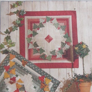 May include: A quilt pattern for a 25 inch by 25 inch quilt called "Leaves & Log Cabins" by Four Corners. The pattern features a red, green and white quilt with a leaf design.