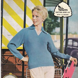 May include: A vintage knitting pattern booklet titled No. 609 Patons Totem Knitting Wool with T.V. Designs. The cover features a person wearing a blue long-sleeved jumper with a collared V-neck and white trim, paired with light-coloured trousers.
