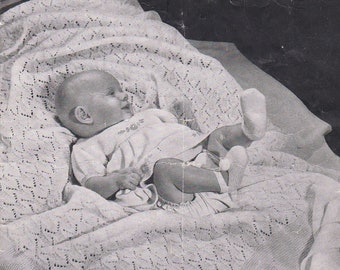 May include: Black and white photograph of a baby lying on a crocheted blanket. The blanket has a diamond pattern. The photo is from a vintage knitting book titled "Patons Knitting Book (Specialty) No. 155" and includes the text "A Patons & Baldwins' Publication - 7d."