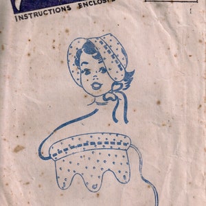 May include: A vintage sewing pattern for a child's bonnet. The pattern is printed on light brown paper with blue ink. The pattern includes a drawing of a girl wearing the bonnet. The text on the pattern reads "Fashion Cut Pattern Instructions Enclosed" and "Sew it with Sylko".