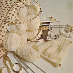 May include: A vintage magazine cover titled "WOOLCRAFT" with text "How to Knit, How to Crochet." The image features cream-colored yarn, knitting needles, scissors, and a knitted swatch. A practical guide to knitting and crochet.