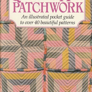 May include: A vintage book cover featuring a quilt pattern with pink, yellow, and grey squares. The title is "QUILTING AND PATCHWORK" with the subtitle "An illustrated pocket guide to over 40 beautiful patterns".
