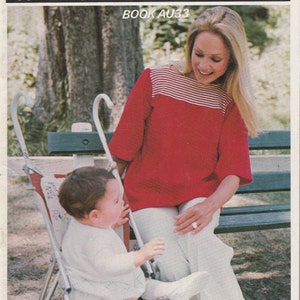 Peut inclure: Une femme portant une chemise rouge et blanche à rayures est assise sur un banc avec un bébé dans une poussette. La femme sourit et regarde le bébé. La poussette est rouge et blanche et a un motif floral. Le texte "Empisal" et "Book AU33" est visible sur l'image.