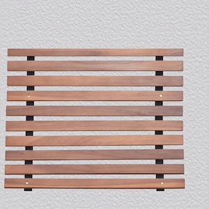 Op de afbeelding: Een rechthoekig houten lattenpaneel met horizontale bruine houten latten en zwarte verticale steunen. De latten zijn gelijkmatig verdeeld en bevestigd met kleine metalen bevestigingsmiddelen. Ontworpen voor decoratief of functioneel gebruik.