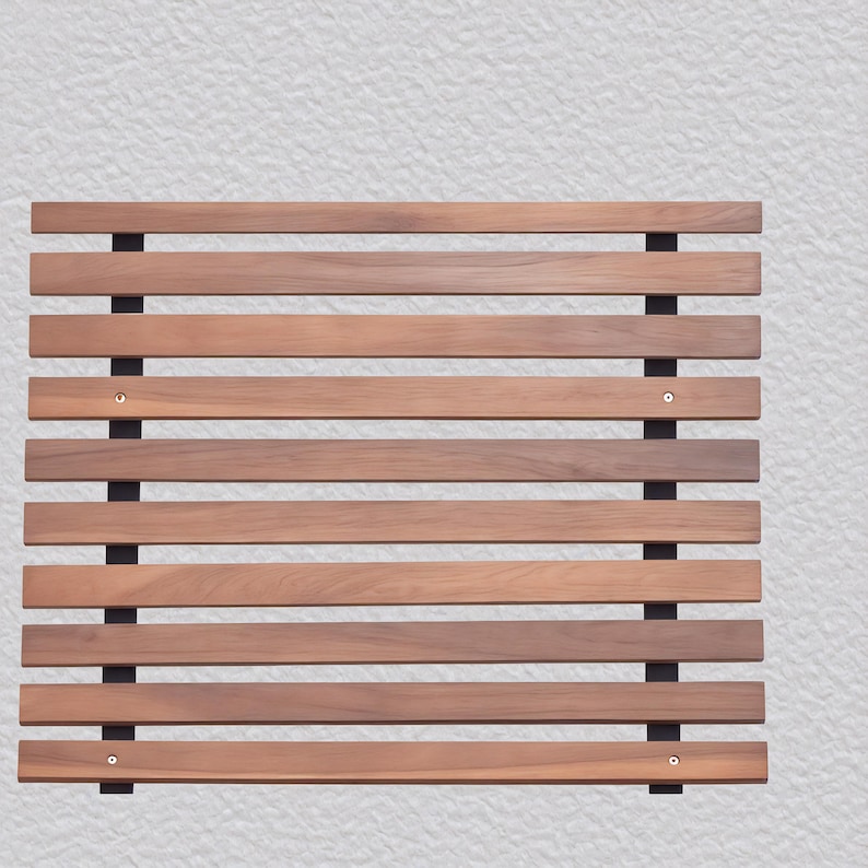 Op de afbeelding: Een rechthoekig houten lattenpaneel met horizontale bruine houten latten en zwarte verticale steunen. De latten zijn gelijkmatig verdeeld en bevestigd met kleine metalen bevestigingsmiddelen. Ontworpen voor decoratief of functioneel gebruik.