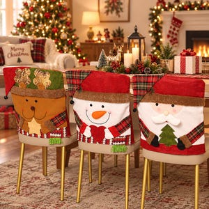 May include: Three chair covers featuring festive holiday designs. The left cover depicts a brown reindeer with gold antlers, the center cover shows a white snowman with a red heart, and the right cover features a Santa Claus with a green tree.
