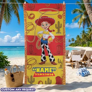 May include: A beach towel featuring a cartoon cowgirl character in a red hat and outfit, with a lasso and cowboy boots design. The towel has a yellow and red background with the text "NAME" and the date "22/03/2026".