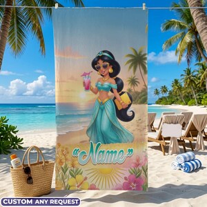 Op de afbeelding: Een strandlaken met een cartoonillustratie van een vrouw in een turquoise outfit, zonnebril en een drankje. De handdoek heeft een strandsc&egrave;ne-achtergrond met de tekst "Name" en "Custom Any Request".