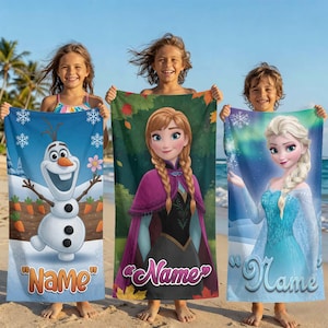 May include: Three children holding personalized beach towels featuring characters from the movie Frozen. The towels display Olaf, Anna, and Elsa, with space for a name. The towels are blue, green, and purple.
