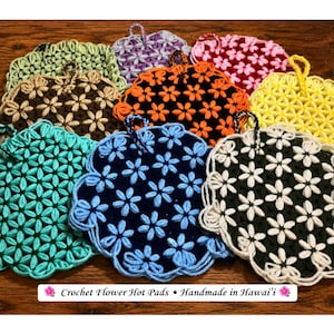 May include: A collection of multi-colored crochet flower hot pads featuring various color combinations including turquoise, black with blue, black with white, yellow, orange with black, and brown. Each pad has a hanging loop and text: Crochet Flower Hot Pads • Handmade in Hawai'i.