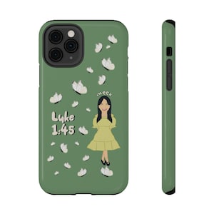 Puede incluir: Una funda de teléfono color verde salvia con una ilustración de una persona con vestido amarillo rodeada de mariposas blancas. El texto "Lyke 1:45" y la palabra "meek" están impresos en blanco con borde negro en la parte posterior.
