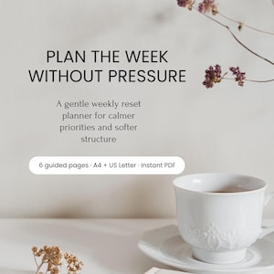 May include: A white teacup and saucer with a floral design sit on a white surface next to a planner. The text on the planner reads "PLAN THE WEEK WITHOUT PRESSURE". Dried flowers are in the background. The planner is A4 and US Letter size.