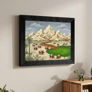 May include: Framed artwork depicting a whimsical landscape with mountains, a river, and a field of green. The painting features several pink and brown creatures. The artwork is framed in a black wooden frame.