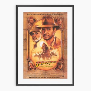 May include: Framed movie poster for "Indiana Jones and the Last Crusade." The poster features Harrison Ford in a brown hat, with Sean Connery and other characters. The title is in a stylized font, with a desert scene in the background.