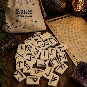 May include: A set of off-white rectangular rune tiles with black engraved symbols, accompanied by a beige drawstring pouch labeled Runes Oracle Game and a printed reference guide featuring a table of symbols and their corresponding meanings.
