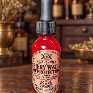 May include: A clear glass dropper bottle filled with bright red liquid. The label features black text reading RITUAL OIL FIERY WALL OF PROTECTION, REPEL DEFEND SHIELD, UNBREAKABLE PROTECTION, and CURIO NOCTURNE, with a black dropper cap on top.