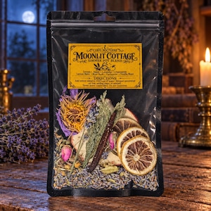May include: A clear plastic pouch containing a Moonlit Cottage simmer pot blend with dried lemon slices, a vanilla bean, rose buds, lavender, and other botanicals. The yellow label lists ingredients including lemon, apple, lavender, and chamomile.