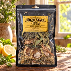 May include: A black resealable pouch containing a dried herb and fruit simmer pot blend. The yellow label reads Curio Nocturne Fresh Start Simmer Pot Blend, listing ingredients like lemon, lemongrass, and rosemary, with directions for use.