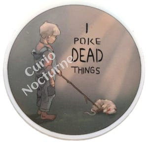 May include: Round button with a cartoon illustration of a child poking a dead animal with a stick. The text "I POKE DEAD THINGS" is printed on the button. The button has a white border and the words "Curio Nocturne" are printed on the side.