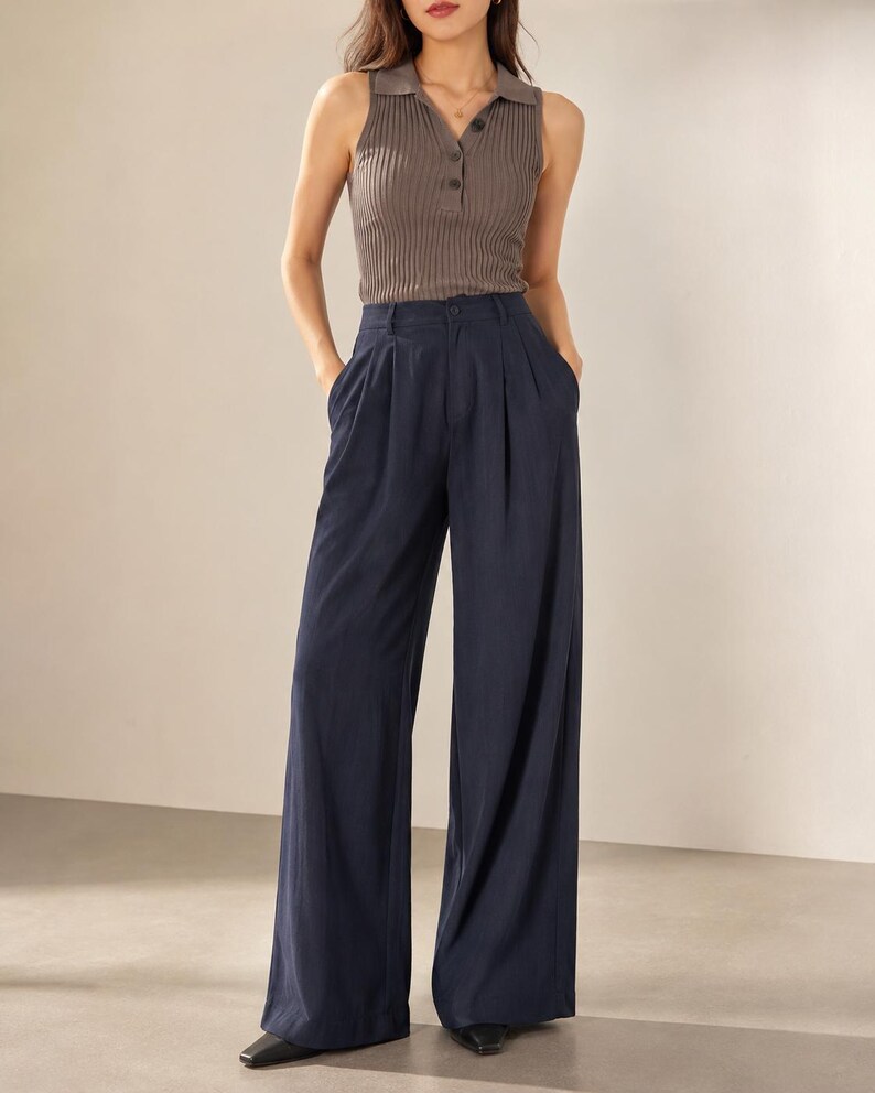 Puede incluir: Un top sin mangas de punto acanalado marr&oacute;n apagado con cuello y tres botones. Combinado con pantalones de pierna ancha azul marino. Los pantalones tienen cintura alta y pliegues en la parte delantera.