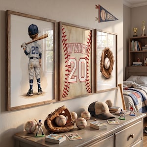 May include: Three framed wall art prints featuring a baseball player in a uniform with number 20, a baseball with red stitching and the name WYATT with number 20, and a leather baseball glove with a ball, displayed above a dresser with baseball gear.