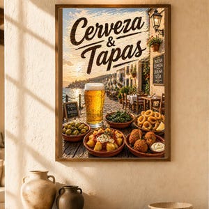 May include: A framed print featuring the words "Cerveza & Tapas" above a scenic image of a Spanish restaurant. The image includes a glass of beer, various tapas dishes, and a coastal town scene. A wooden shelf with vases and a bowl is in the foreground.