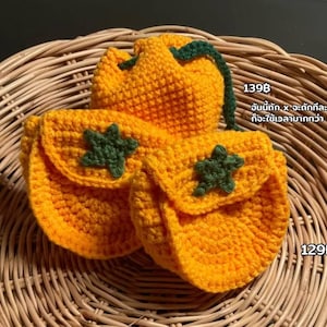 Può includere: Pochette all'uncinetto fatte a mano in arancione brillante con dettagli a stella verdi. Una pochette è in stile coulisse e due sono a patta. Le pochette sono esposte su un cestino di vimini intrecciato. I testi "1398" e "129B" sono visibili.