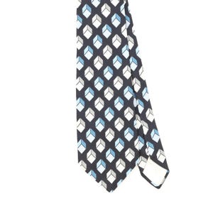 May include: A necktie featuring a repeating geometric pattern of cubes in shades of light blue, white, and grey set against a dark navy background. The design consists of small, uniform shapes arranged in a grid across the entire fabric surface.
