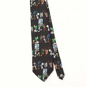 Könnte beinhalten: Eine schwarze Krawatte mit einem sich wiederholenden Muster aus bunten Looney Tunes-Zeichentrickfiguren wie Bugs Bunny, Daffy Duck, Tweety und Marvin der Marsmensch, durchsetzt mit kleinen rechteckigen Illustrationen im Briefmarkenstil.